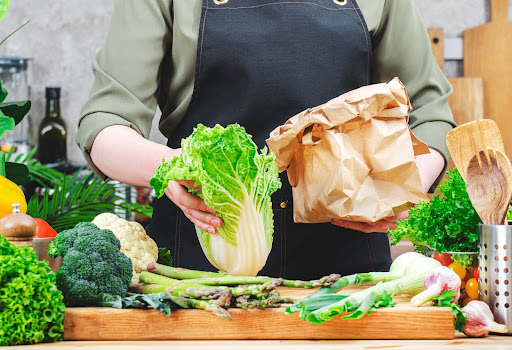 Mulher tirando as verduras da sacola de mercado